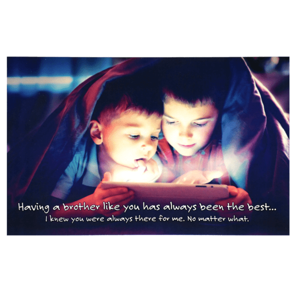 Two children under a blanket looking at an ipad.