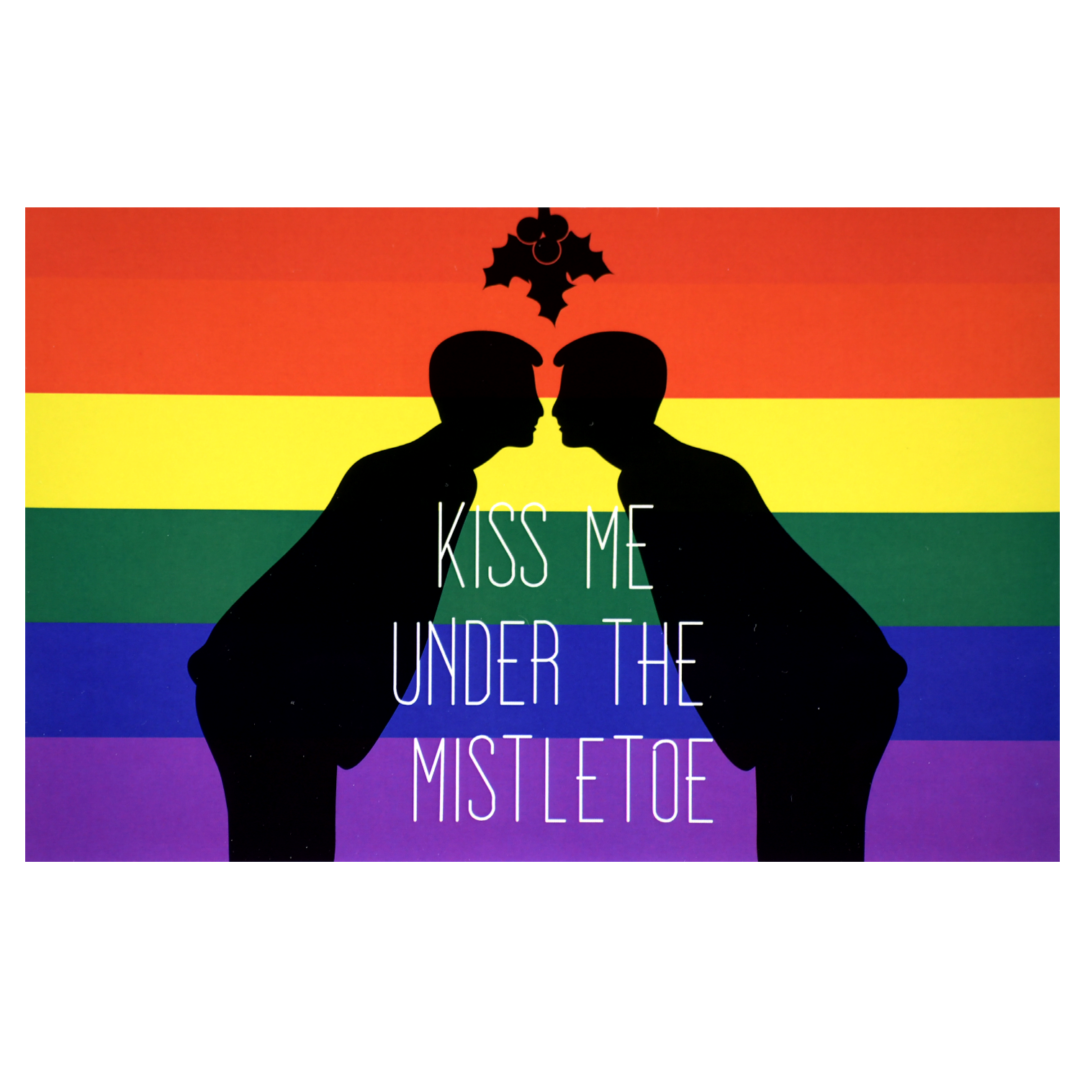 A couple of men kissing in front of the rainbow flag.