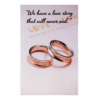 Two wedding rings sitting on top of a card.