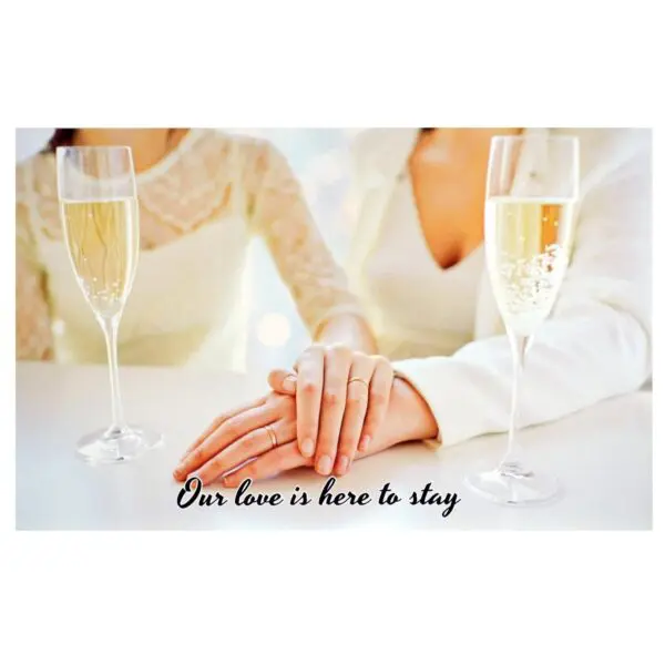 A couple holding hands with champagne glasses in front of them.