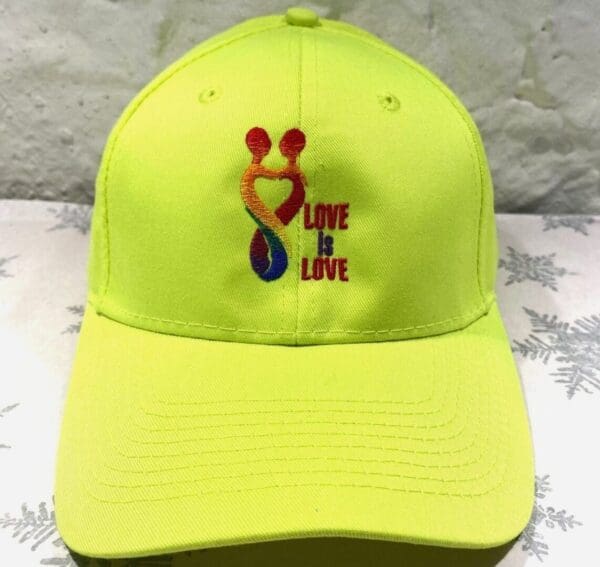A neon yellow hat with the words " love is love ".