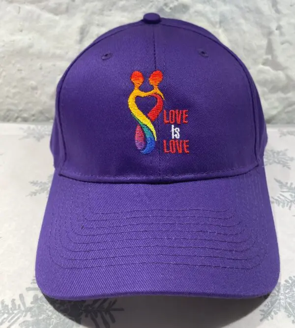 A purple hat with the words " love is love ".