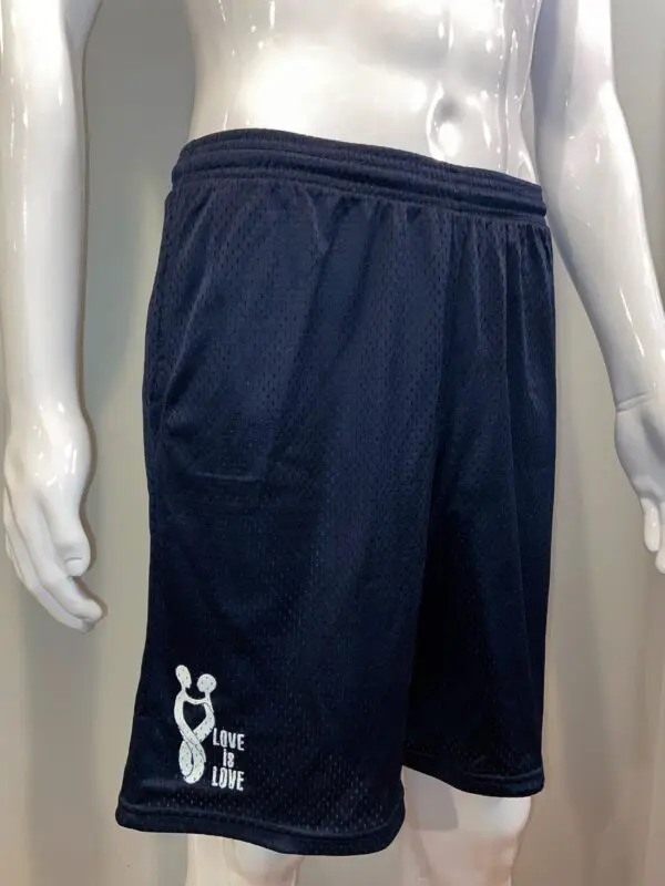 A mannequin wearing black shorts with white lettering.