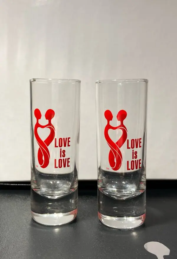 Two glasses with a red ribbon and the words " love is love ".