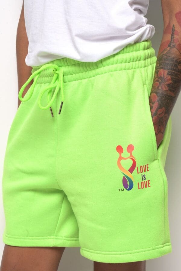 A person wearing neon green sweatpants with the words " love is love ".