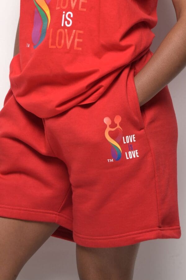 A person wearing red shorts with the words " love is love ".