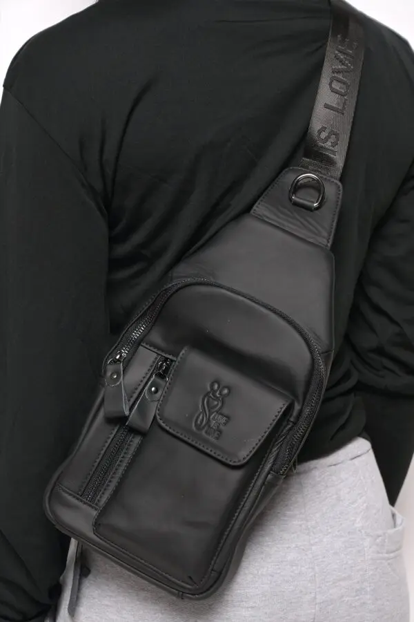 A person wearing a black bag with a strap around it.