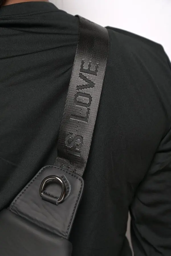 A close up of the shoulder strap on a black jacket