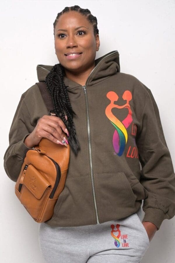 A woman holding her purse and wearing a brown jacket.