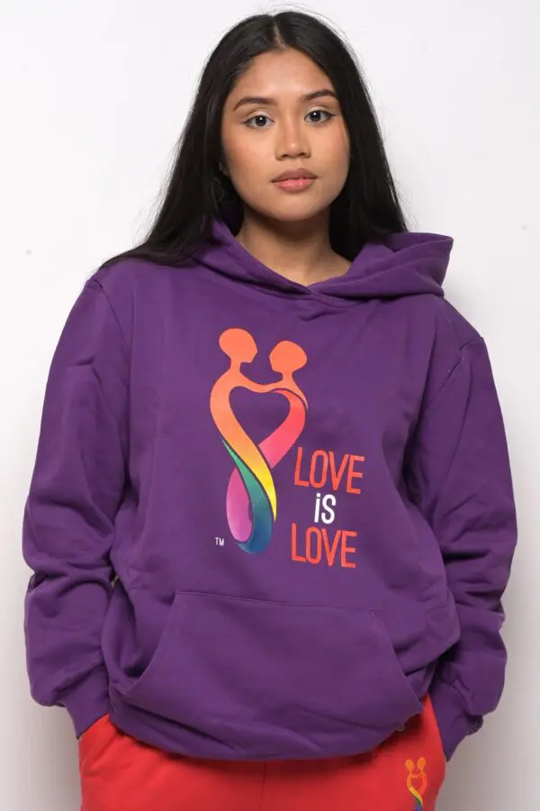 A woman wearing a purple hoodie with the words " love is love ".