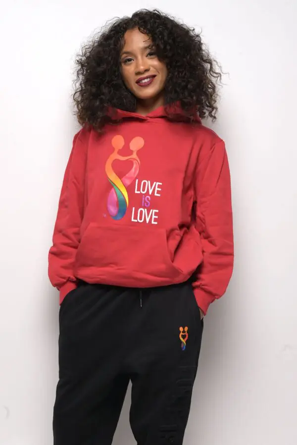 A person wearing a red hoodie with the words love is love on it.