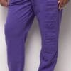 A person wearing purple pants standing next to a wall.