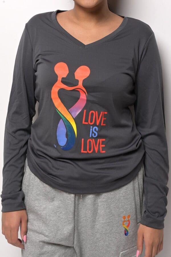 A woman wearing a long sleeve shirt with the words " love is love ".