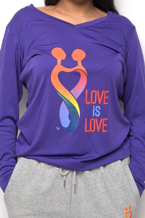 A person wearing a purple shirt with the words " love is love ".