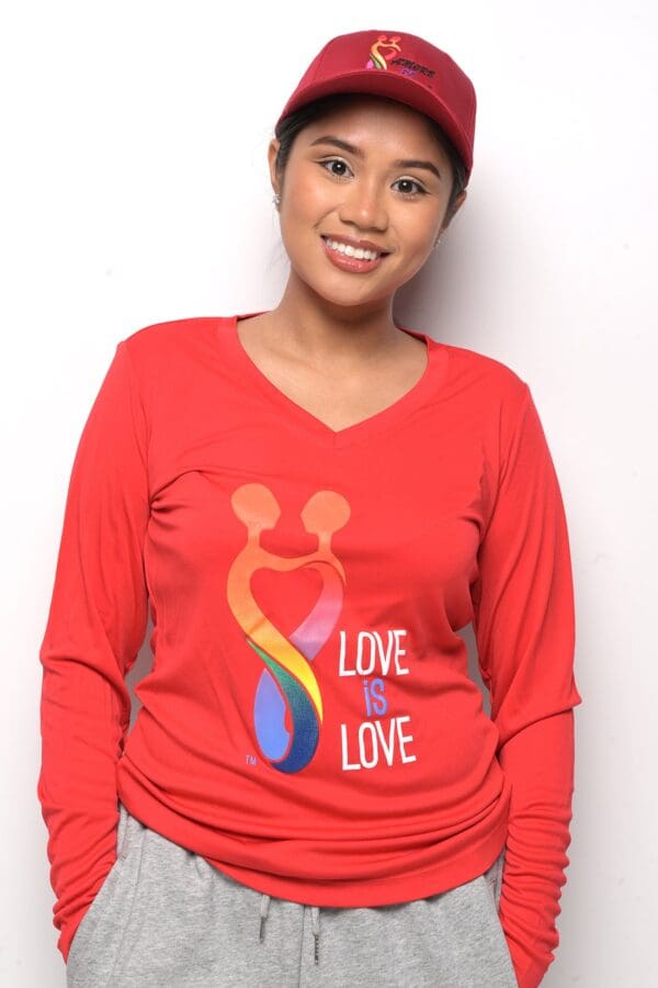 A woman wearing a red shirt with the words " love is love ".