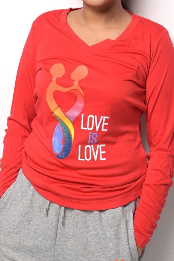 A woman wearing a red shirt with the words " love is love ".