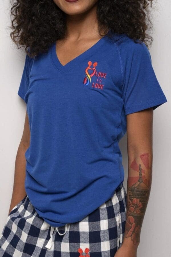 A woman wearing blue shirt and plaid shorts.
