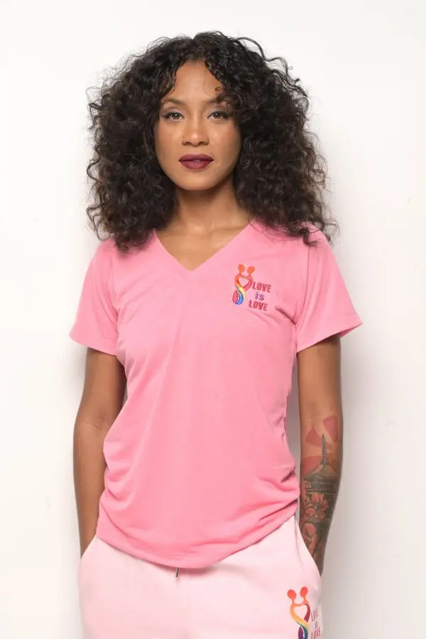 A woman wearing a pink shirt with a tattoo on the side.