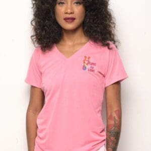 A woman wearing a pink shirt with a tattoo on the side.