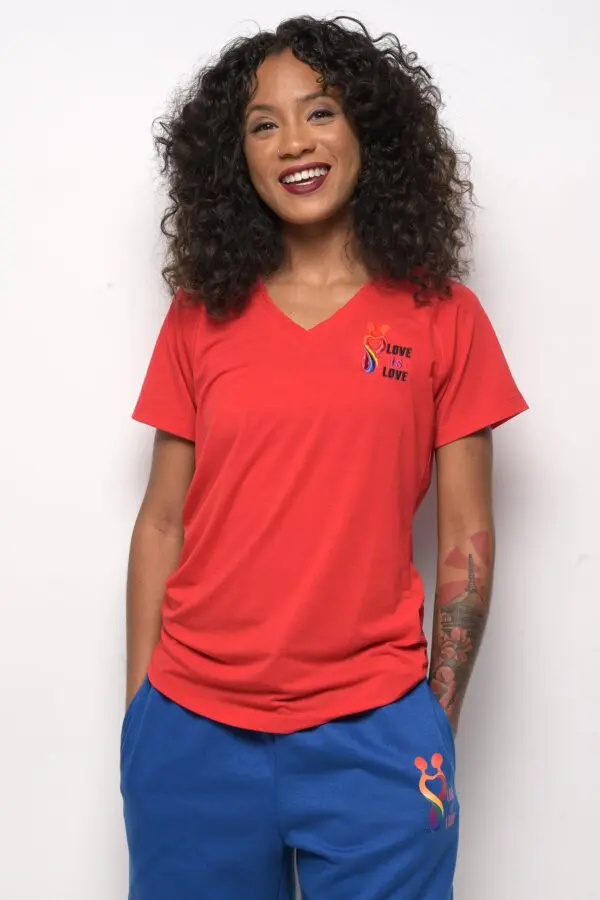 A woman wearing red shirt and blue shorts.