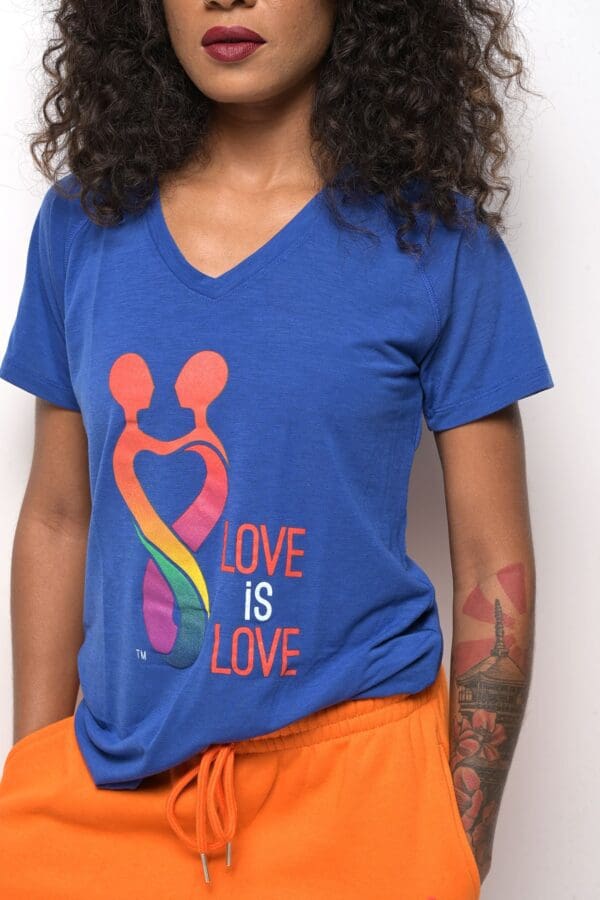 A woman wearing an orange and blue shirt with the words " love is love ".