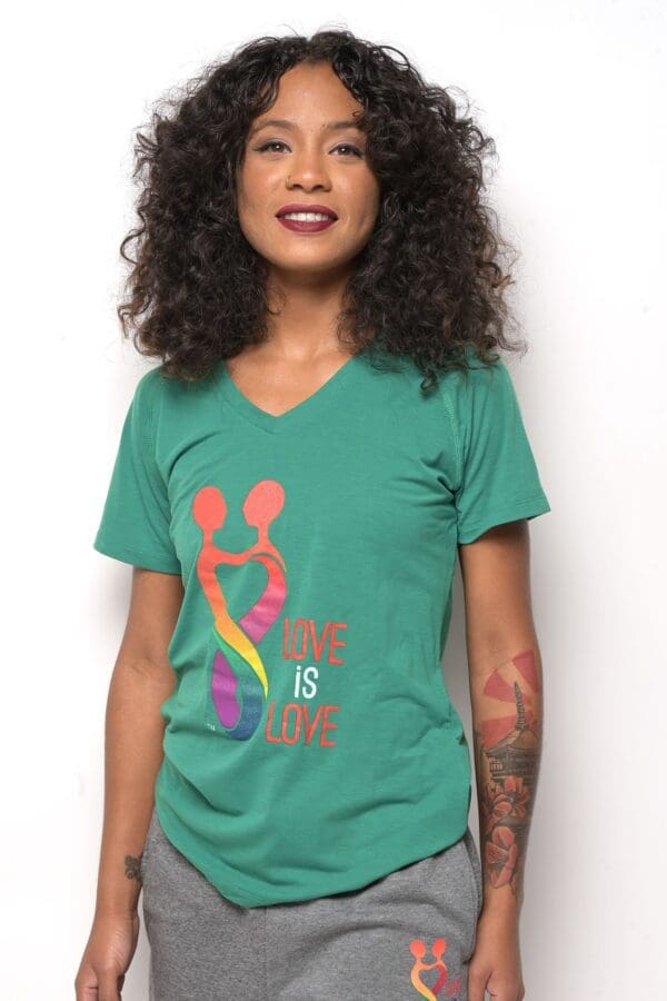 A woman wearing a green shirt with the words " love is life ".