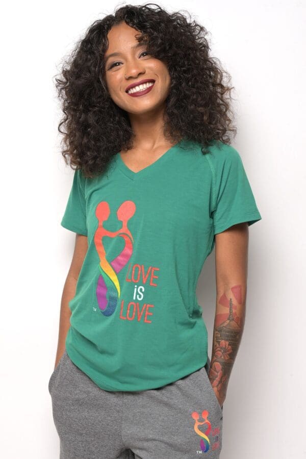 A woman wearing a green shirt with the words " love is love ".