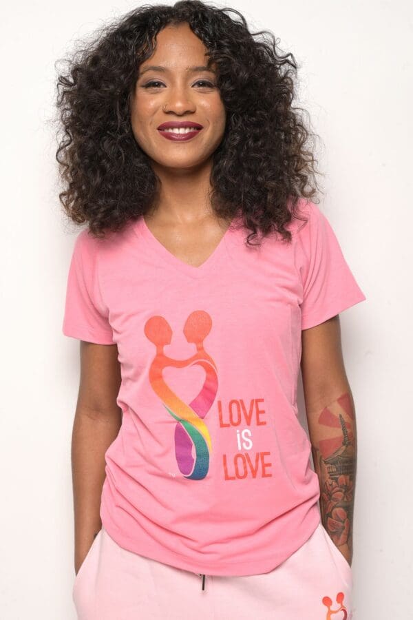 A woman wearing a pink shirt with the words " love is love ".