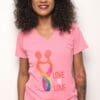 A woman wearing a pink shirt with the words " love is love ".