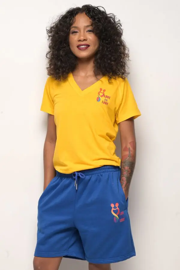 A woman wearing blue shorts and yellow shirt.