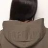 A woman with long hair and a brown jacket.