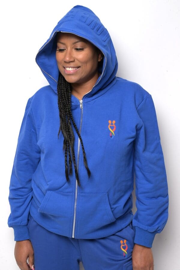 A woman wearing a blue hoodie with a logo on the front.