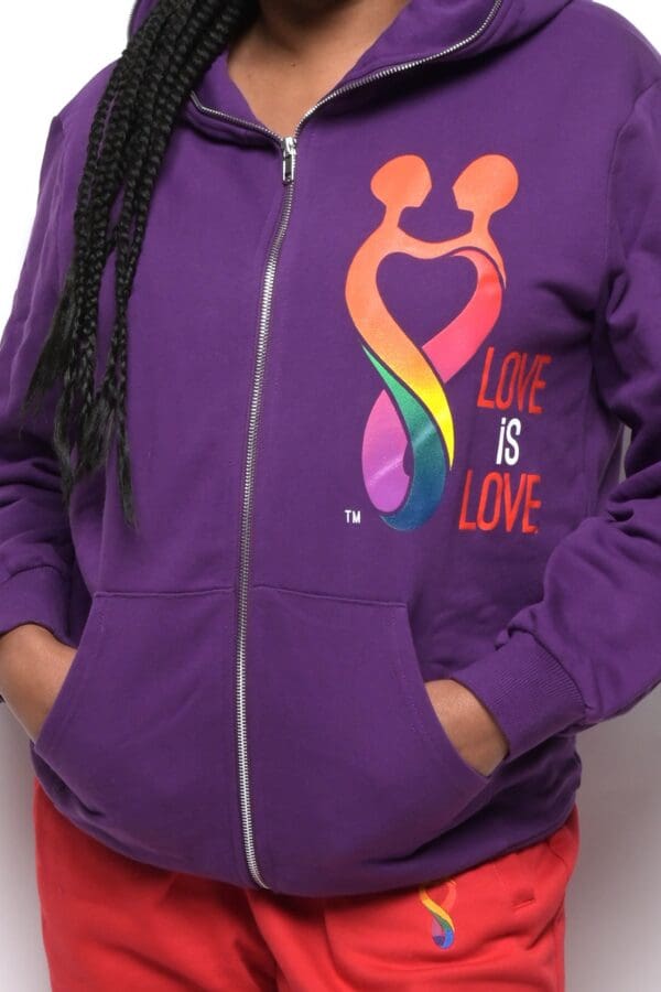 A person wearing purple hoodie with rainbow design.