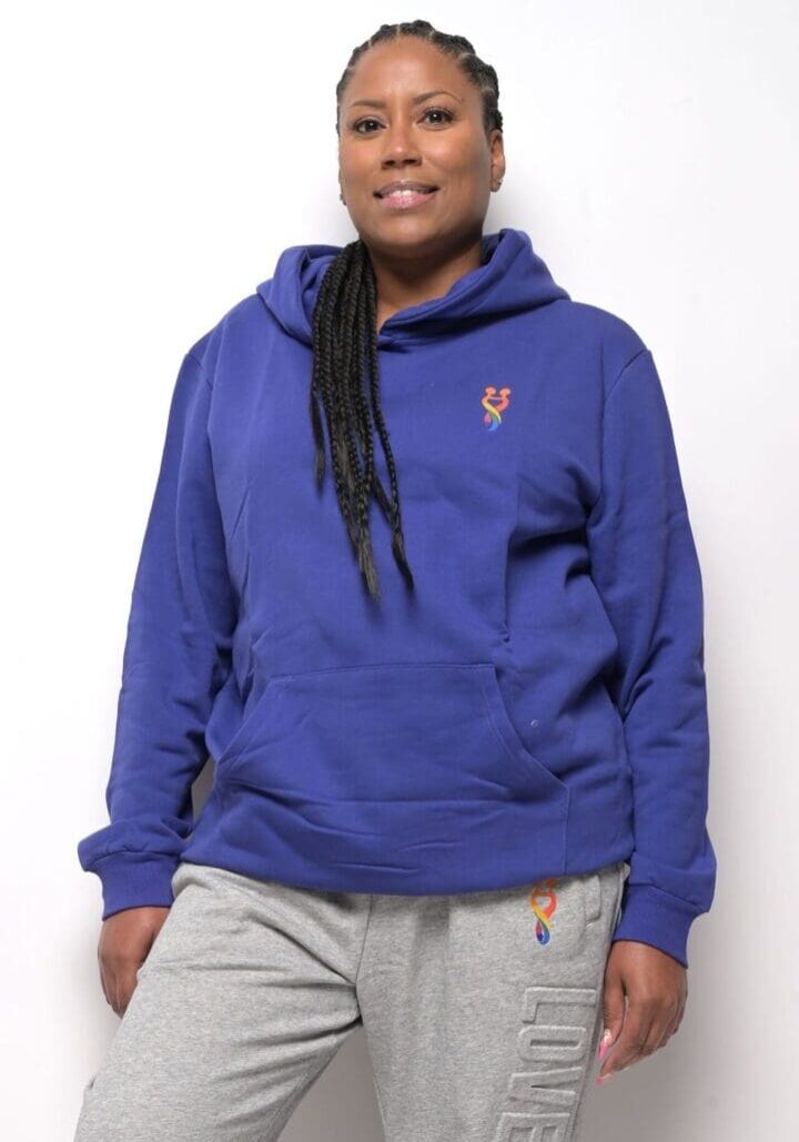 A woman wearing a blue hoodie with a small orange fox on it.